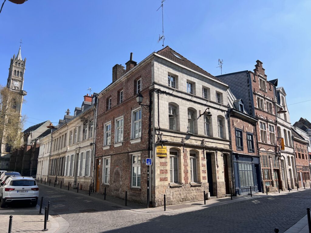 Charming view of historic buildings in Valenciennes, France under a clear blue sky.